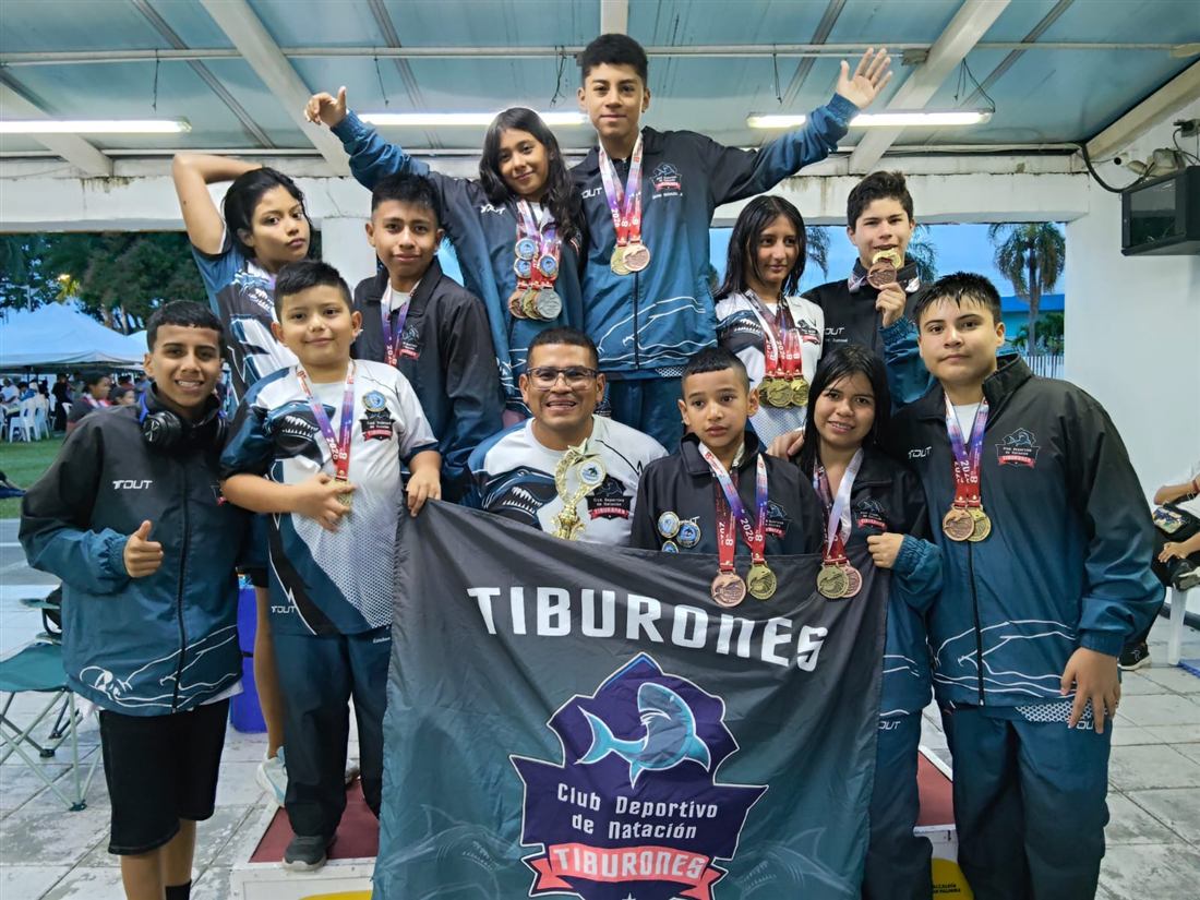 Nadadores del club posando con medallas y el trofeo del club