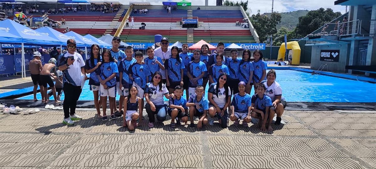 Cuerpo técnico del club junto al equipo completo en la piscina
