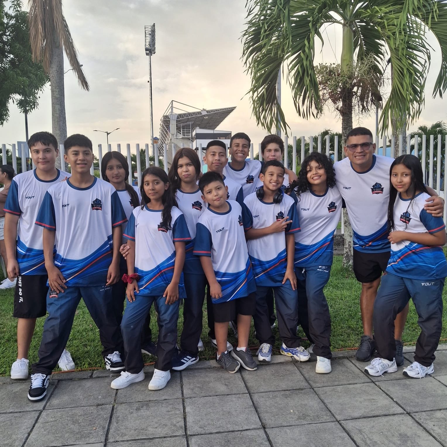 Equipo Tiburones con sus uniformes junto al entrenador