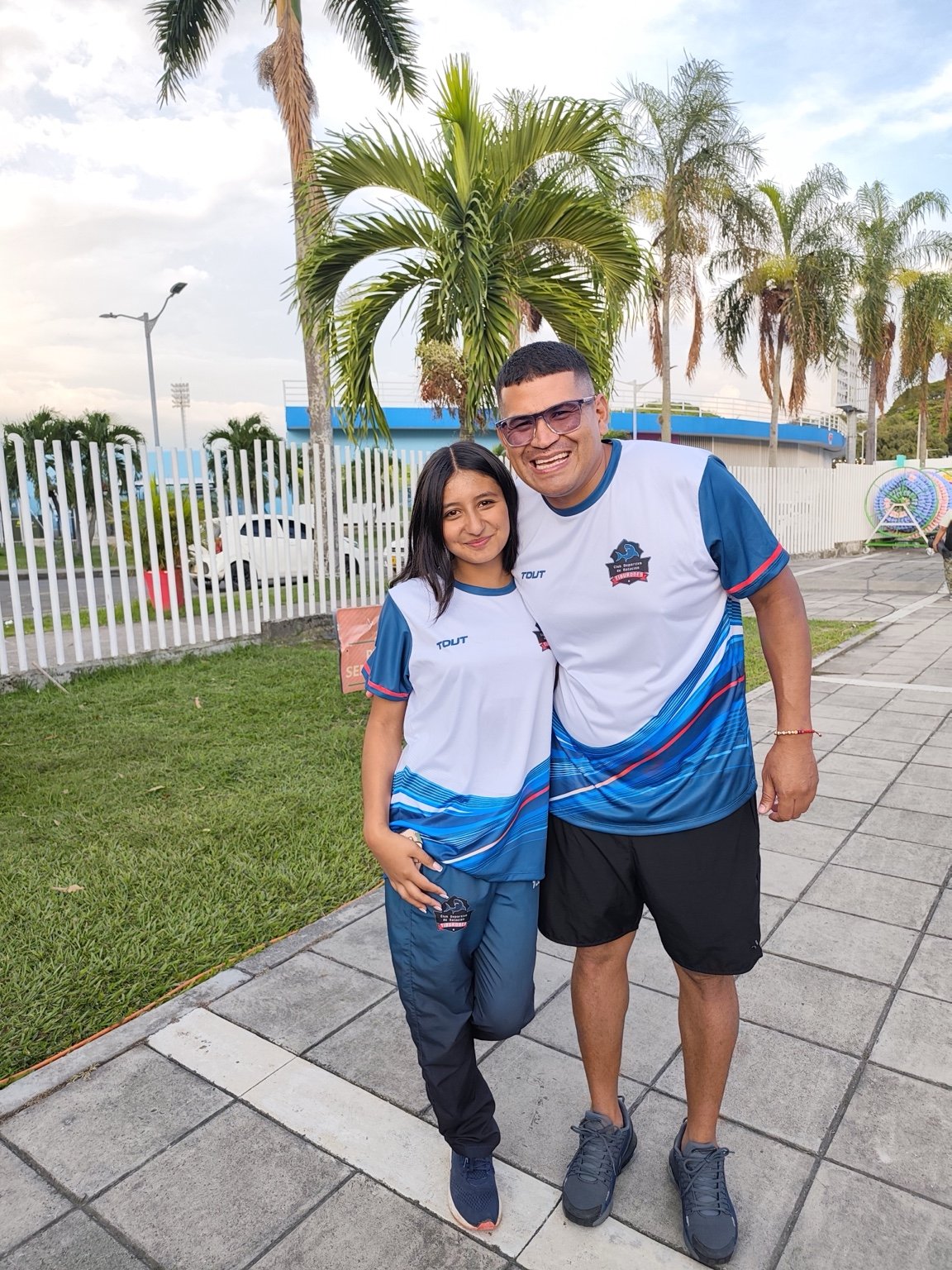 Nadadora de Tiburones junto al entrenador en una salida del equipo