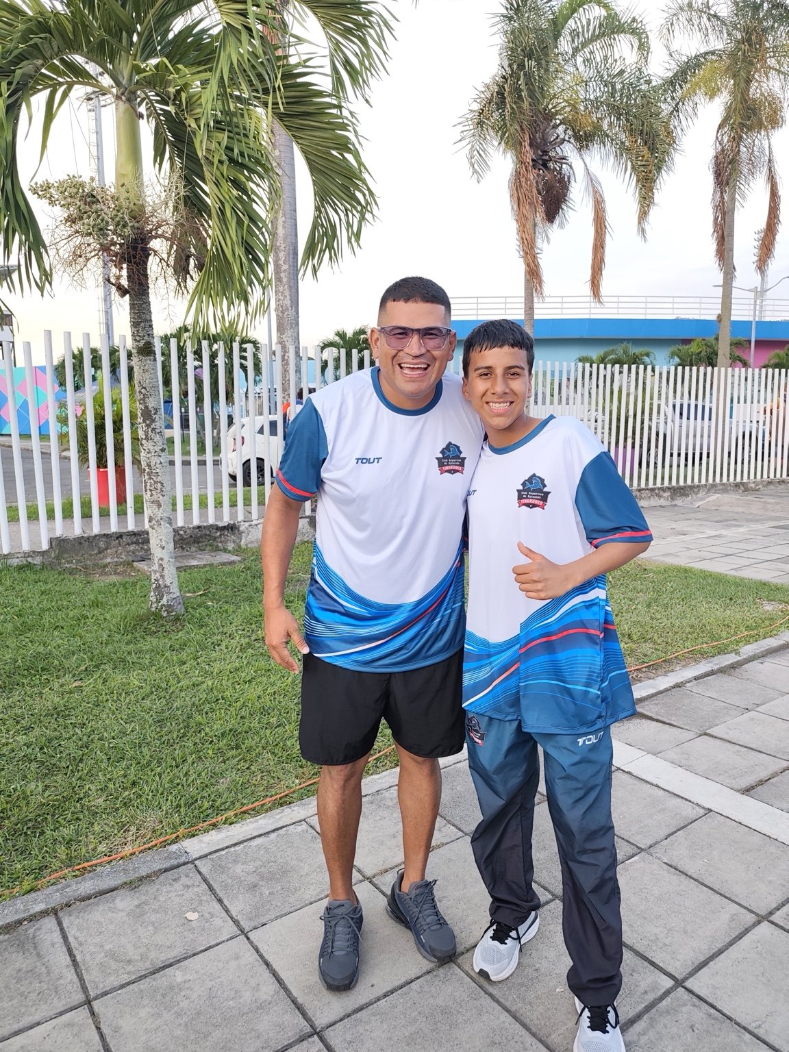 Entrenador y nadador de Tiburones con el uniforme del club
