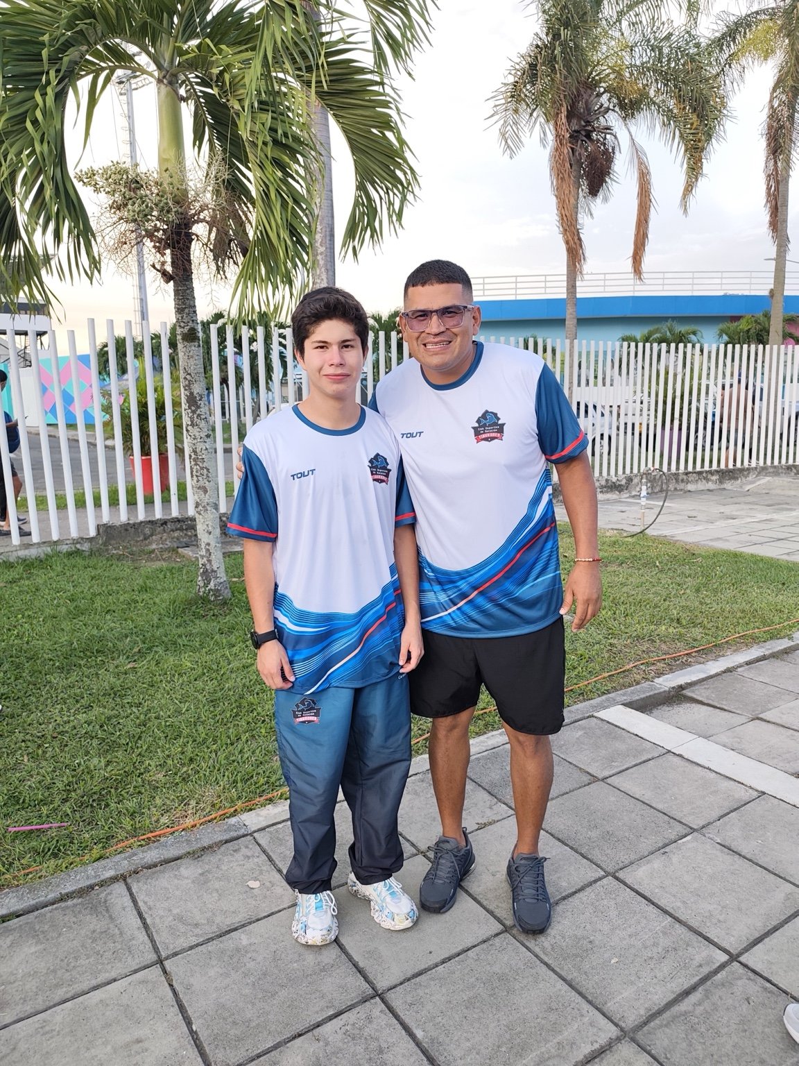 Nadador de Tiburones junto al entrenador en una salida del club