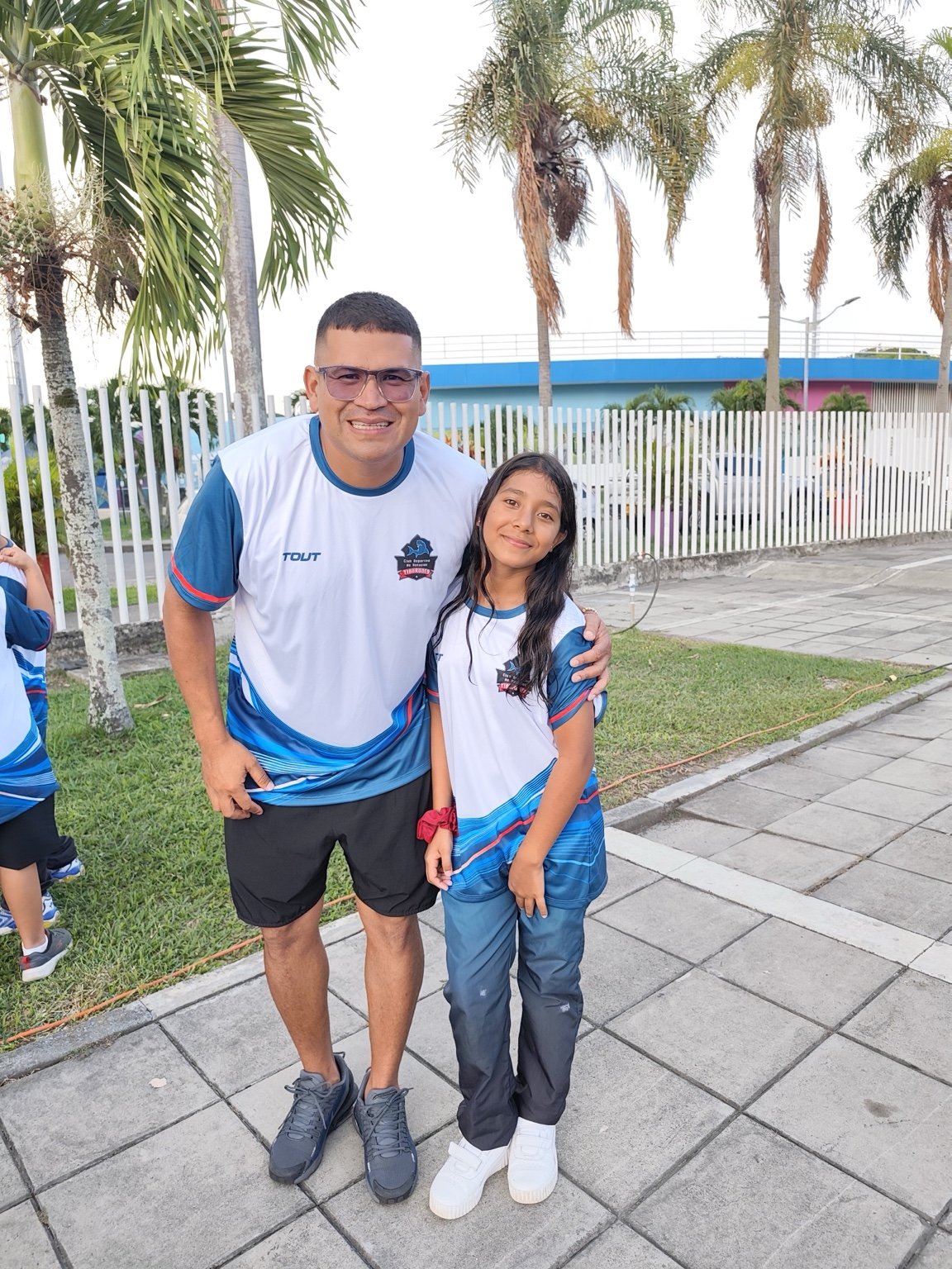 Entrenador del club junto a una nadadora de Tiburones